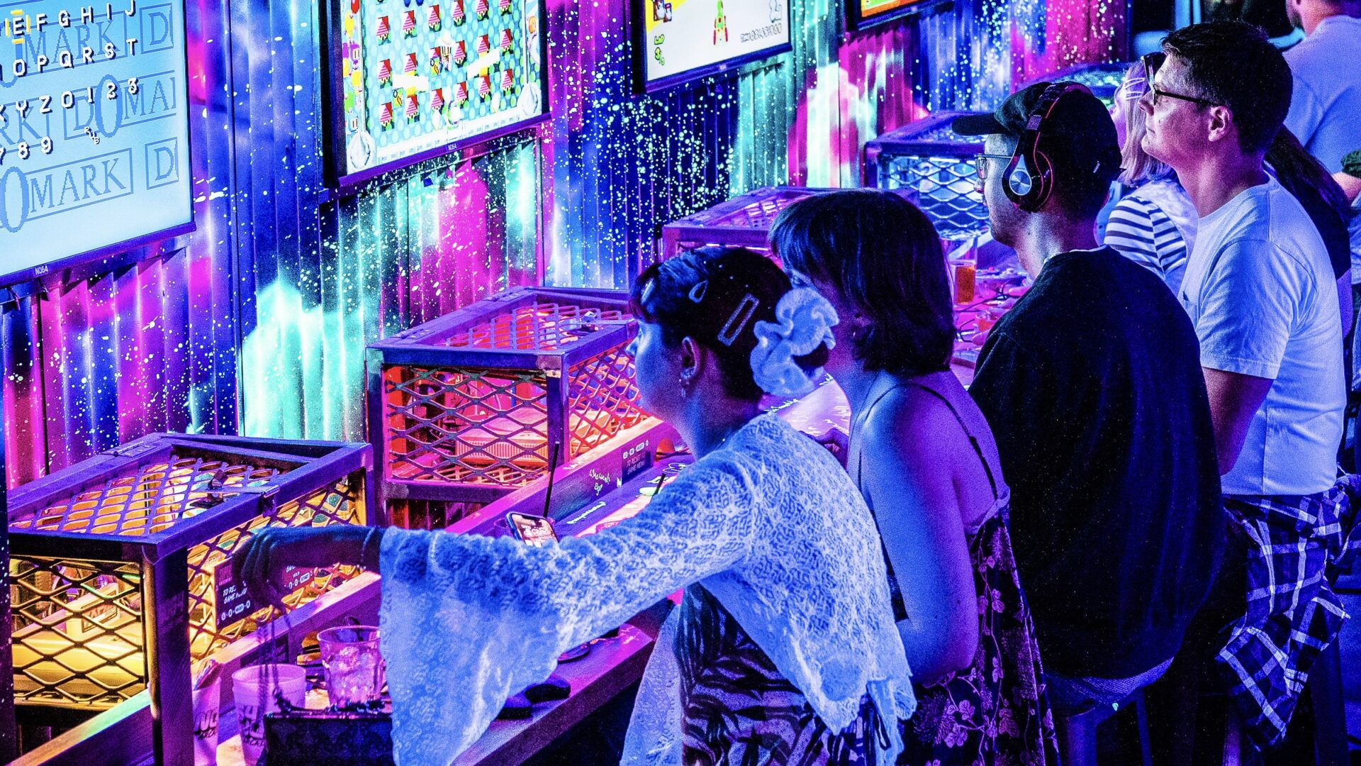 People playing on the free-to-play retro consoles at NQ64 Arcade Bar bartender